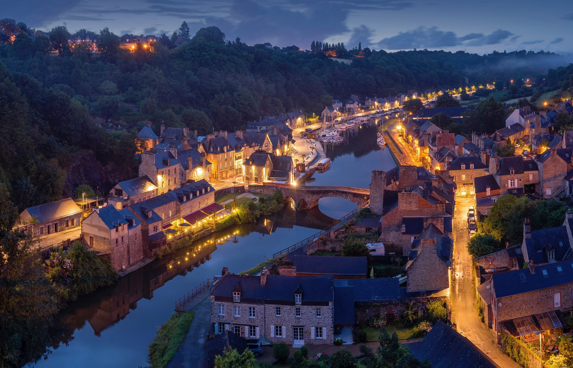 Twilight aerial view of a traditional French riverside village.